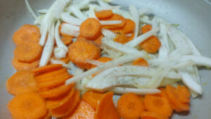padella con carote e finocchi conditi con sale e pepe